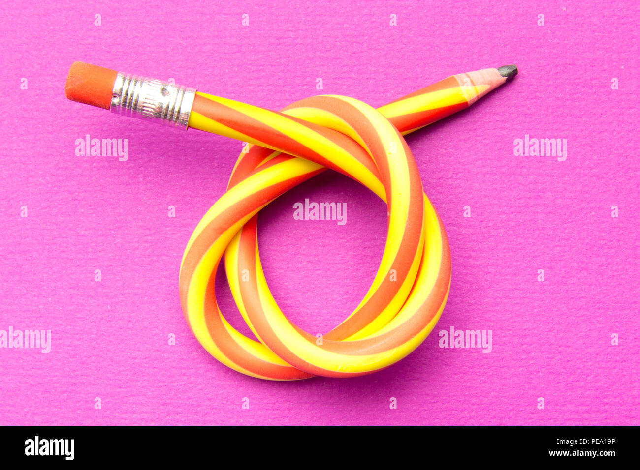 Flexible pencil on a textured cardboard background. Bent pencils two-color  Stock Photo - Alamy