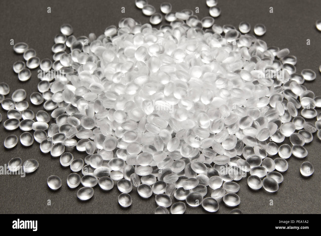 Transparent Polyethylene granules on dark .HDPE Plastic pellets. Plastic Raw material . IDPE. Stock Photo