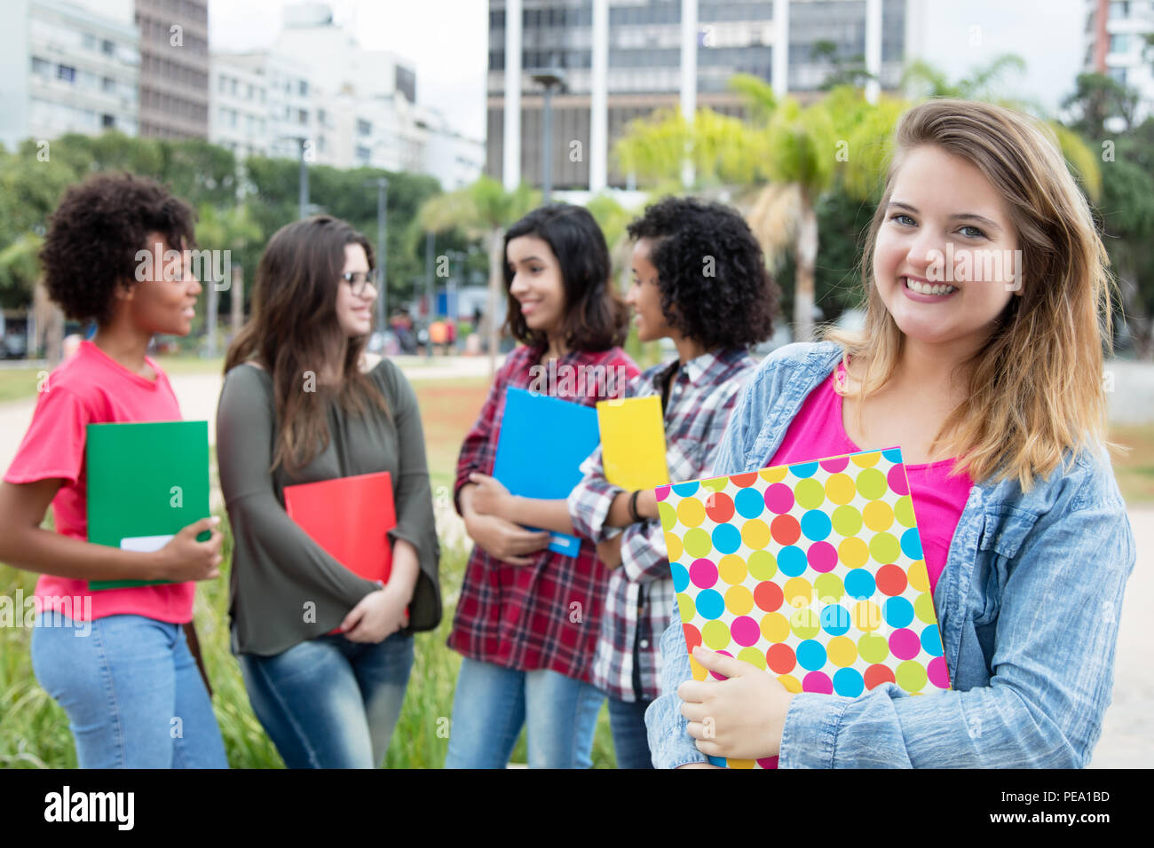 Caucasian female student with group of international students outdoors on campus of university Stock Photo