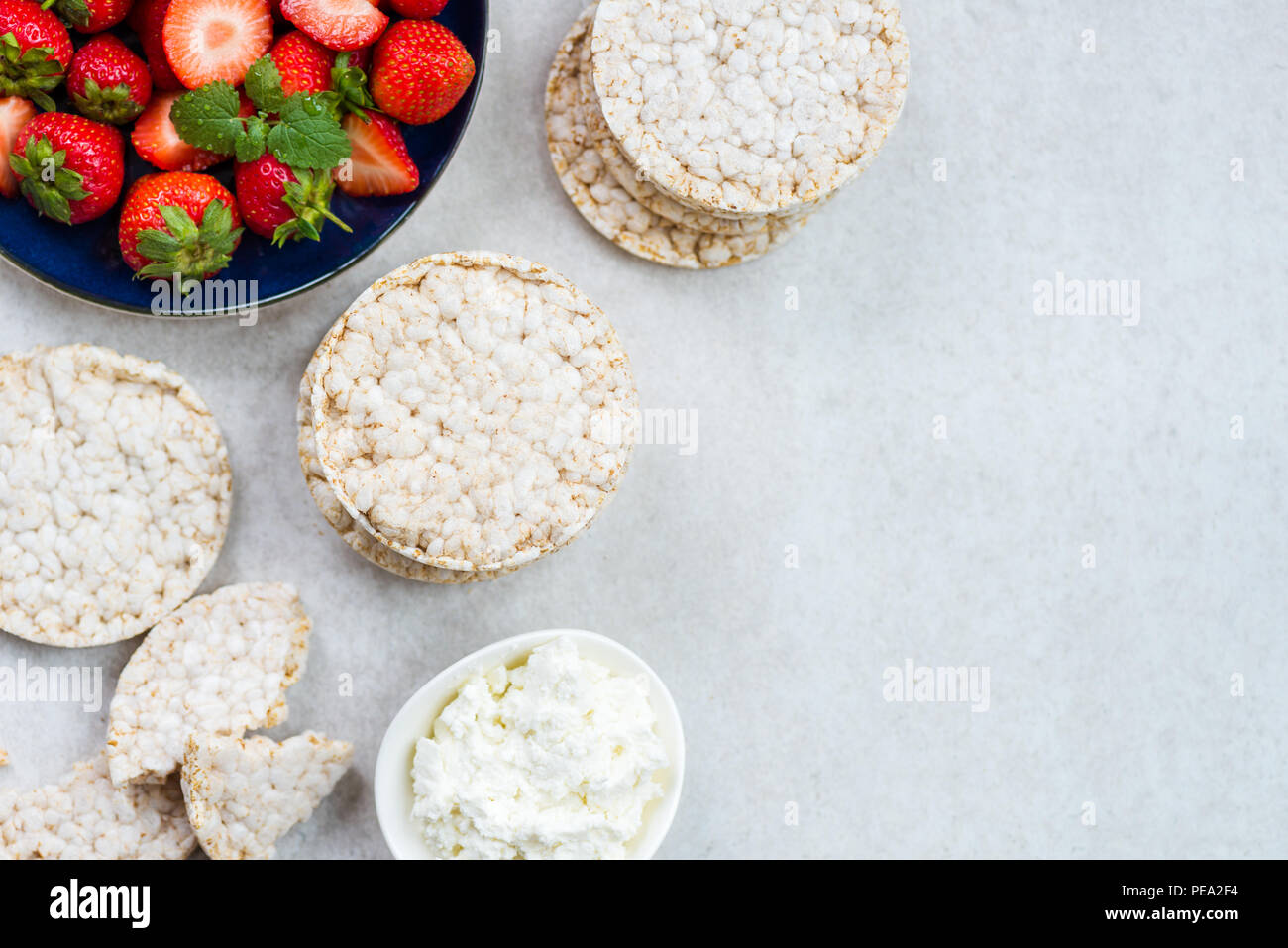 Healthy Snack from Rice Cakes with Ingredients nearby such as Ricotta  Cheese and Strawberries on Light Background Stock Photo - Alamy
