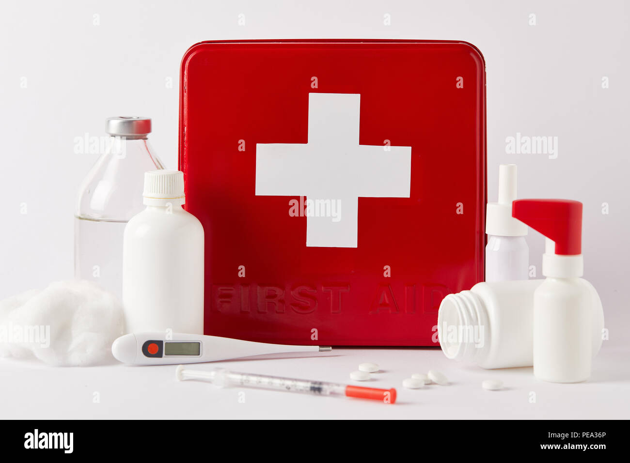 close-up shot of red first aid kit box with different medical bottles ...