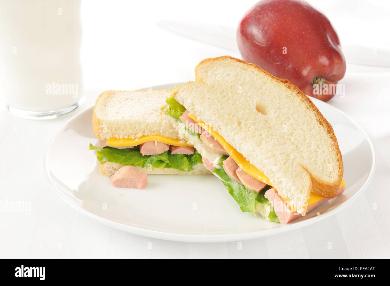 Vienna sausage sandwich with an apple and milk on a high key setting