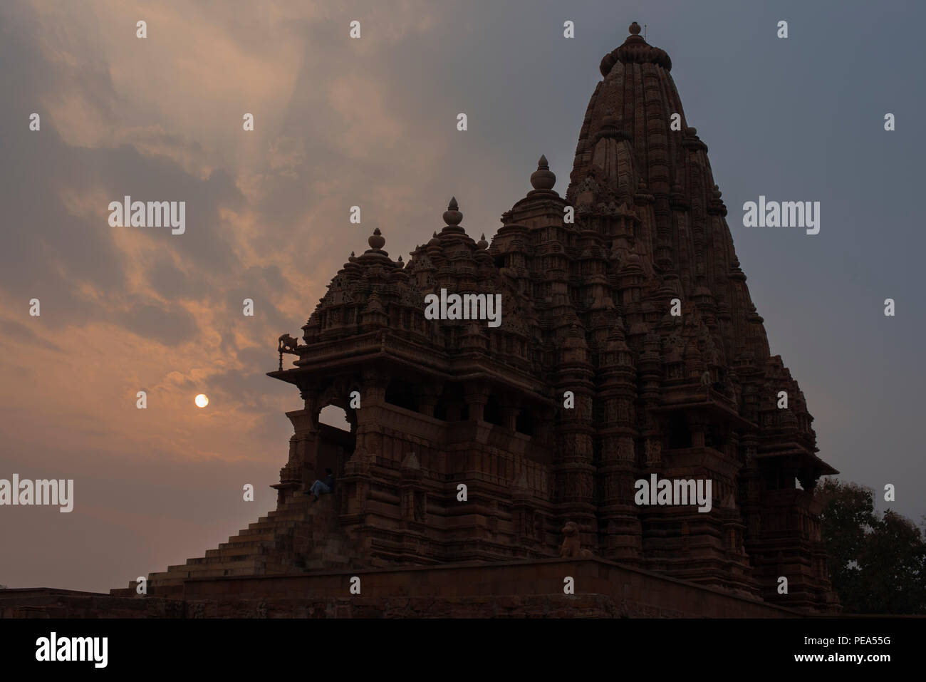 Ancient Kandariya Mahadev Temple with intricate carvings and statues against sunset dedicated to Hindu God Lord Shiva symbolizing power and strength Stock Photo