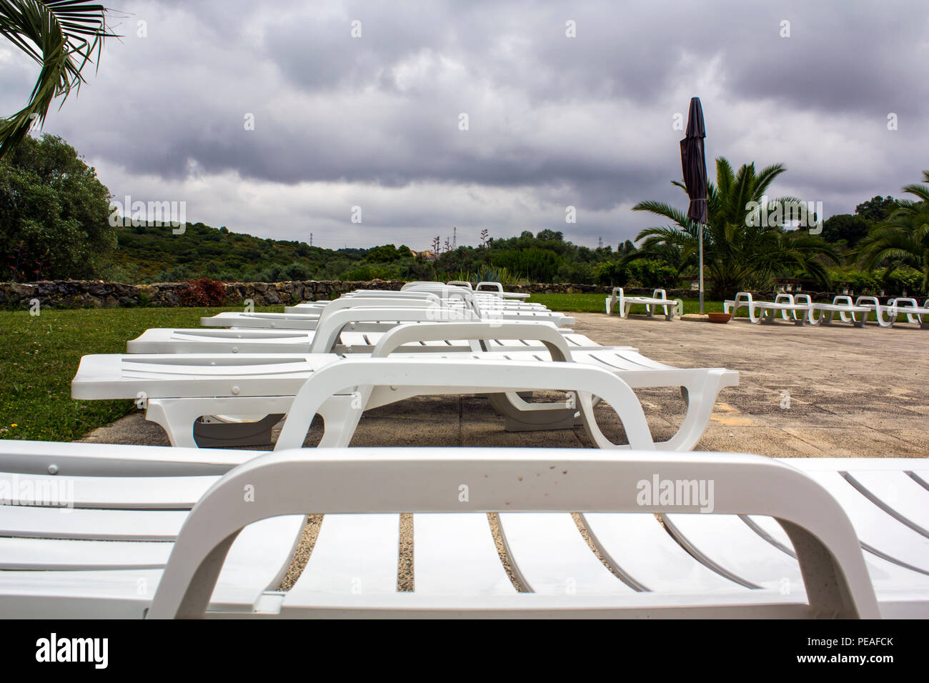 sun-loungers-beside-swimming-pool-stock-photo-alamy