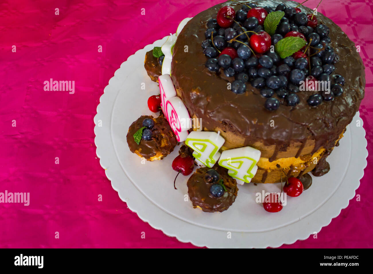 Layered birthday cake with chocolate and red fruits Stock Photo - Alamy