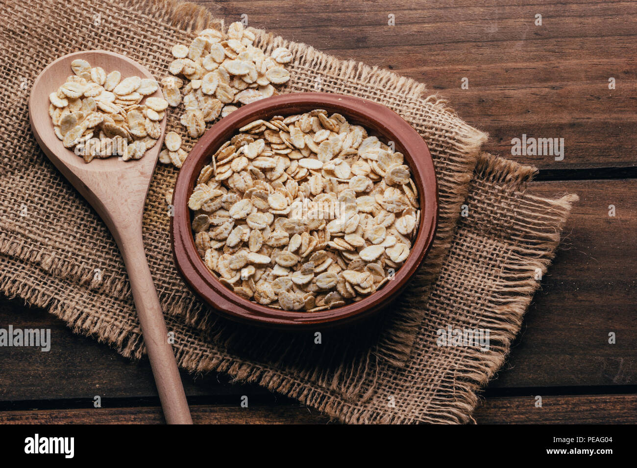 Container filled with uncooked oats, rustic style Stock Photo