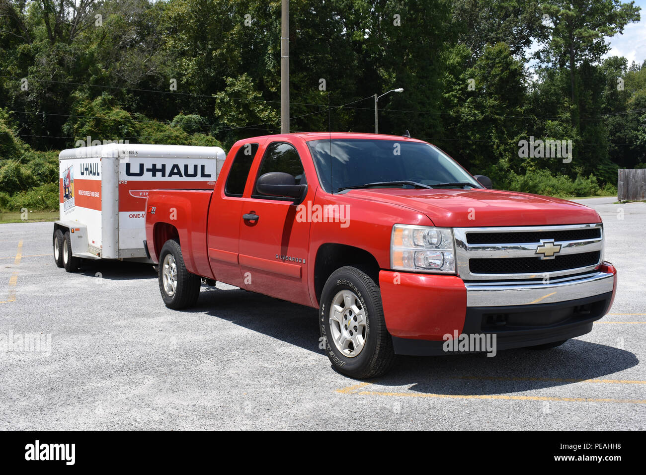 A 2007 Chevrolet Truck towing a tandem axle UHaul Trailer Stock Photo