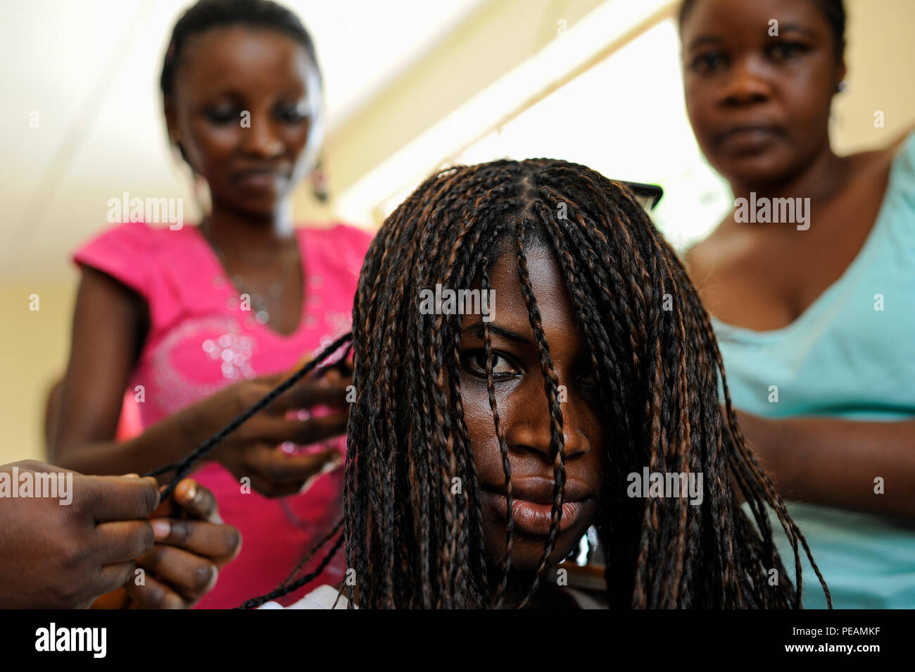SIERRA LEONE Freetown , Kamayama Youth Empowerment Centre in Mende, beautician training for young women, braiding with artificial hair Stock Photo