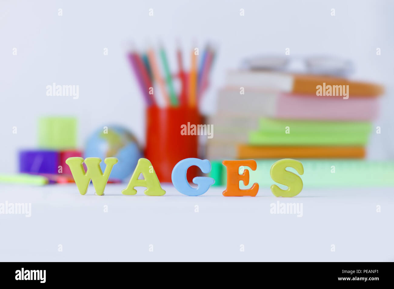 word wages on a blurred background of school supplies .photo with copy space Stock Photo