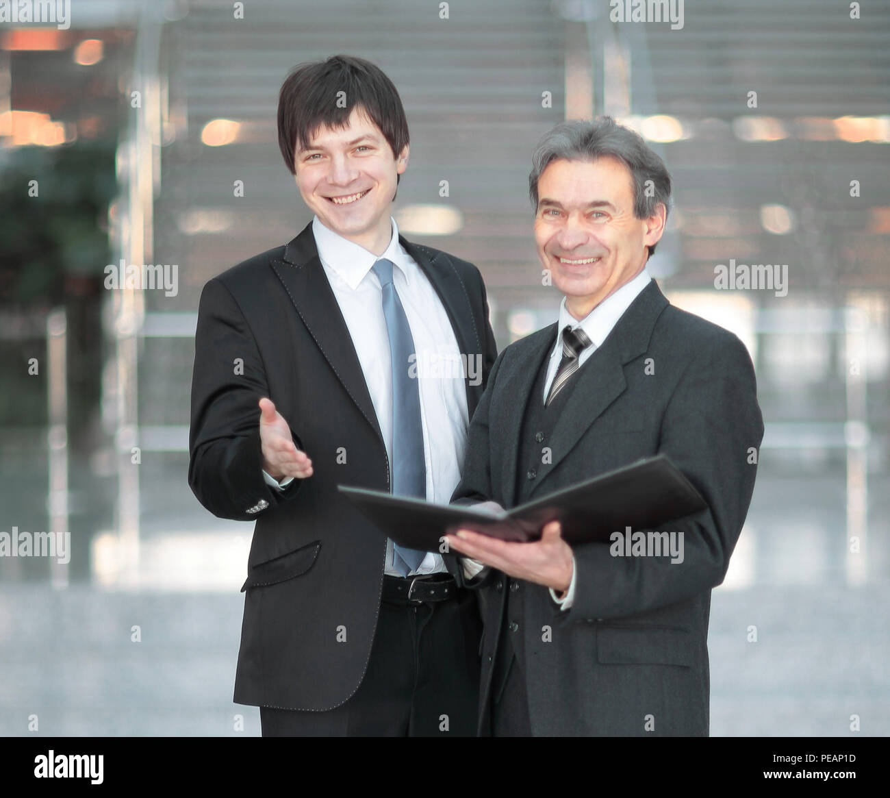 business partners with documents standing in the office. Stock Photo