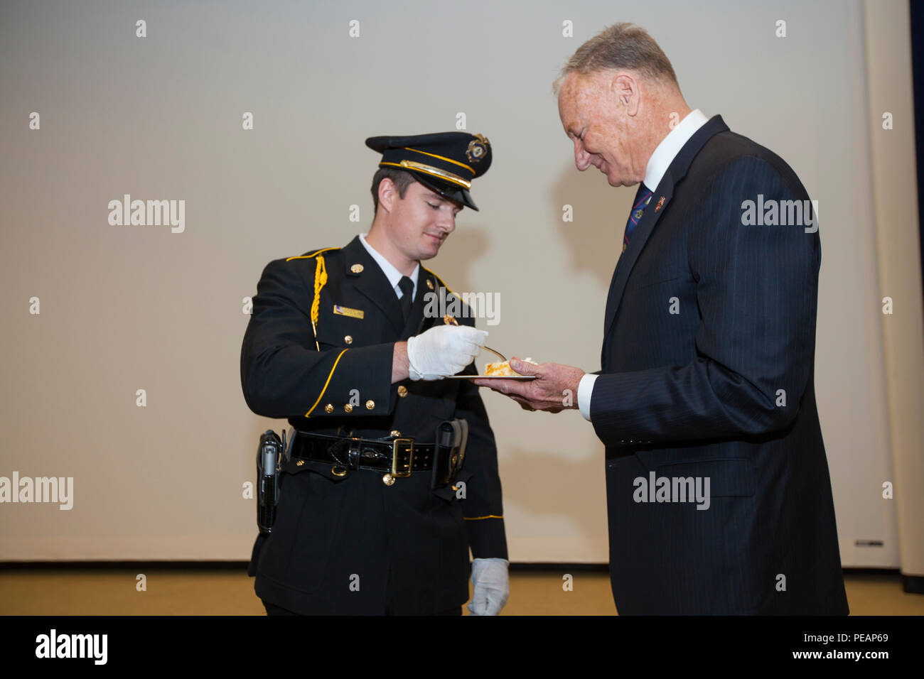 U.S. Marine Corps retired Col. Mark W. Adams, right, presents a piece of cake to William J. Gostling during a cake cutting ceremony at the U.S. State Department in Washington, Nov. 3, 2015. Every year, U.S. Marines celebrate the Marine Corps birthday by having the oldest and youngest Marine who are present cut and eat the first piece of cake. (U.S. Marine Corps Photo by Cpl. Alejandro Sierras/ Released) Stock Photo