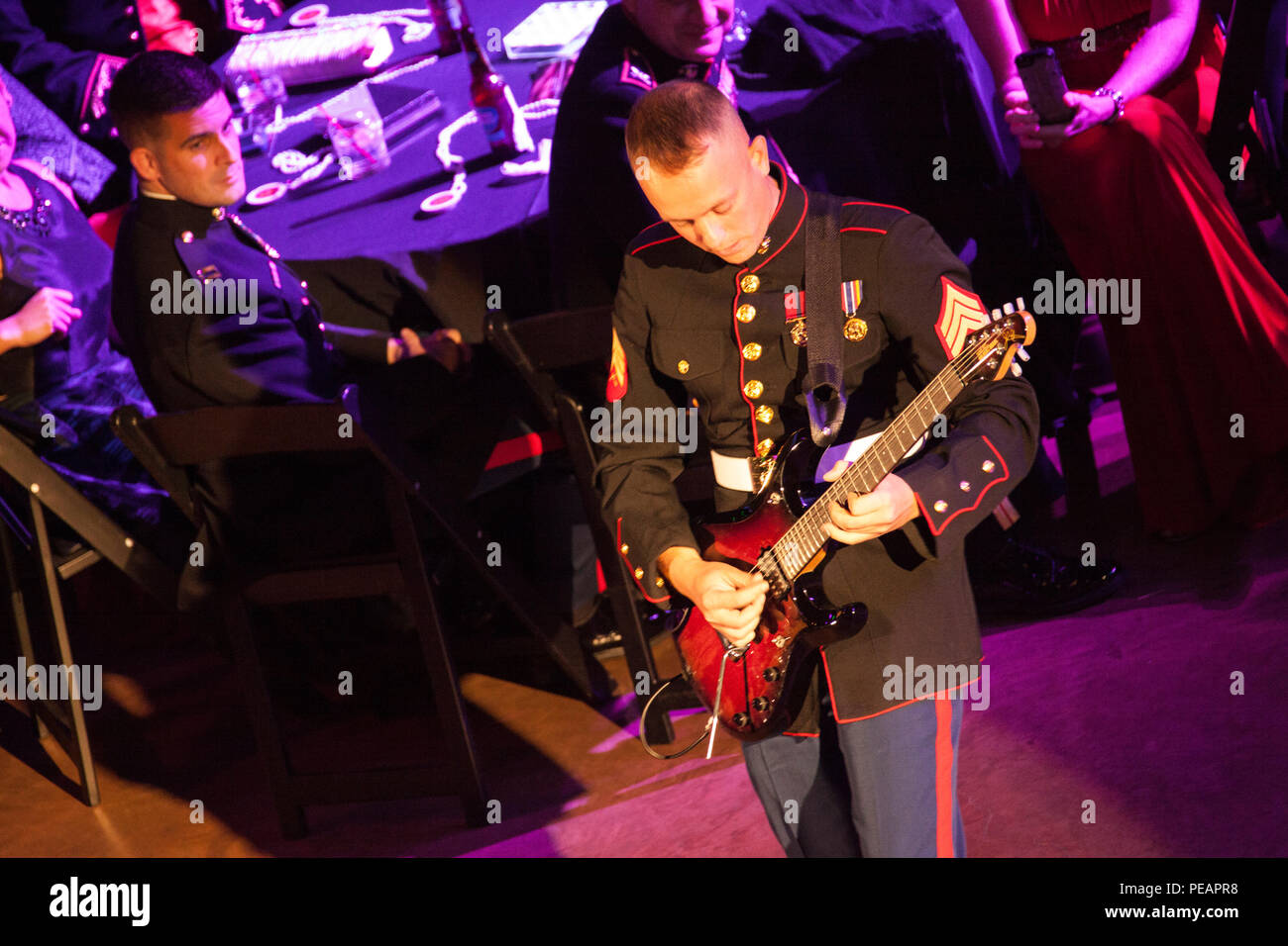 U.S. Marine Sgt. Samuel Gardner with Marine Corps Band New Orleans plays the electric guitar during their performance for the celebration of the 240th Marine Corps Birthday Ball at Mardi Gras World, New Orleans, La., Nov. 21, 2015. This year’s celebration honors those past, present, and future Marines throughout history and marks the 240th Marine Corps Birthday since its founding on Nov. 10, 1775. (U.S. Marine Corps photo by Kimberly Aguirre/Released) Stock Photo