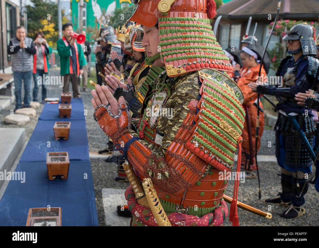 Marines and Japanese locals pray for the deceased samurai at the Kuragake Castle Festival in Kuga, Iwakuni, Japan, Nov. 22, 2015. The festival honors the local Kuga samurai who urged their castle lord to take a last stand against a much larger enemy force. Participants marched from the Kuga train station to the town square before they reenacted the final confrontation of the samurai who marched to battle in the 16th century. (U.S. Marine Corps photo by Lance Cpl. Aaron Henson/Released) Stock Photo