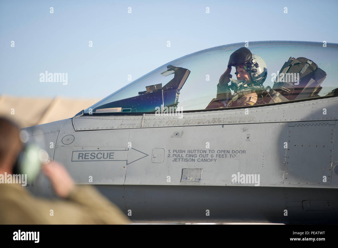 Col. Henry Rogers, 455th Expeditionary Operations Group commander, salutes from the cockpit of an F-16 Fighting Falcon before a sortie with the 421st Expeditionary Fighter Squadron at Bagram Air Field, Afghanistan, Nov. 27, 2015. Rogers reached the 3,000-flying hour milestone and 1,000 combat-hour milestone while serving on his eighth combat deployment flying F-16s. (U.S. Air Force photo by Tech. Sgt. Robert Cloys/Released) Stock Photo