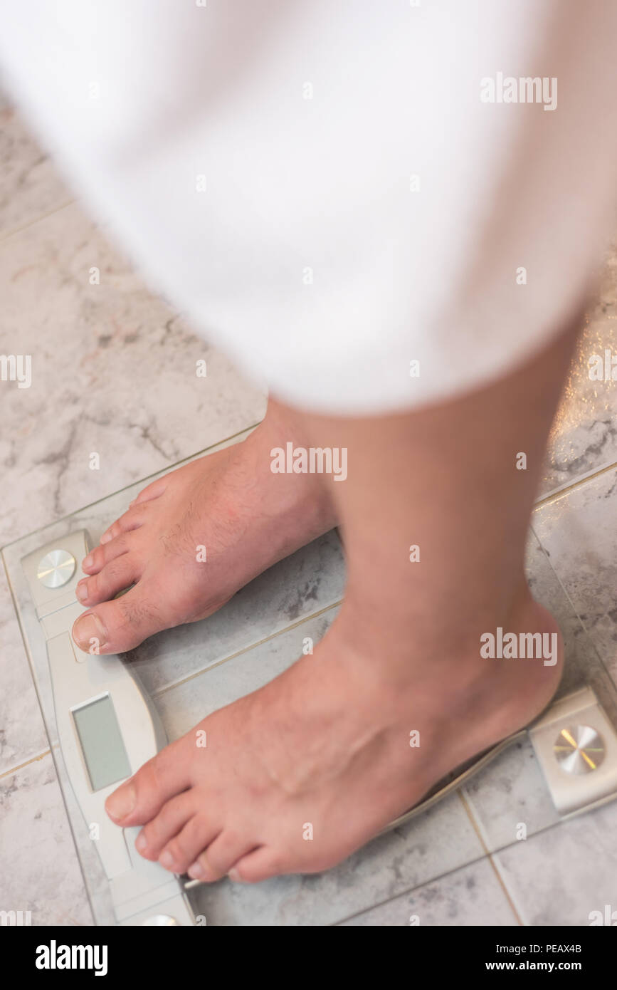 Man feet standing on weight scale Stock Photo Alamy