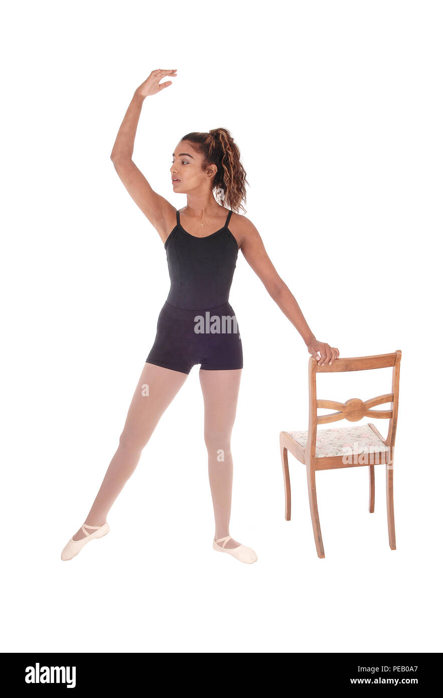 A lovely slim young woman in a black ballet outfit praxis some movements for her ballet dancing, isolated for white background Stock Photo