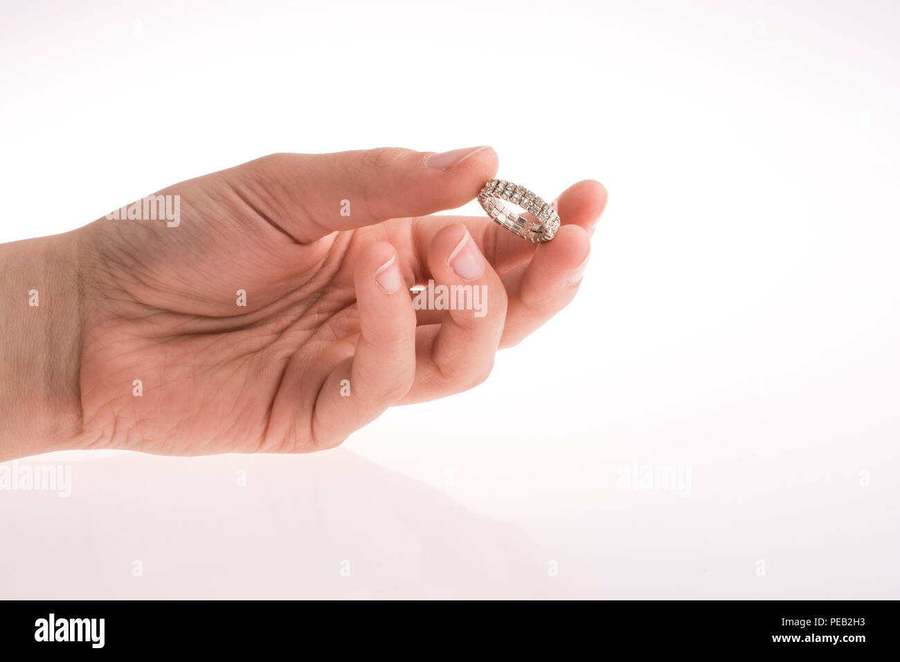 Hand holding a ring on a white background Stock Photo - Alamy