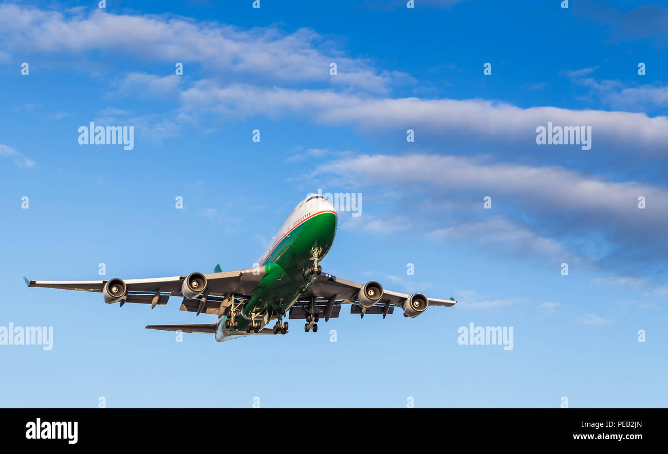 A green and white 747 landing at Vancouver International Airport on a sunny day. Stock Photo