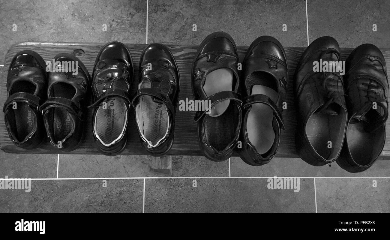 a line up of children's school shoes smallest to biggest Stock Photo