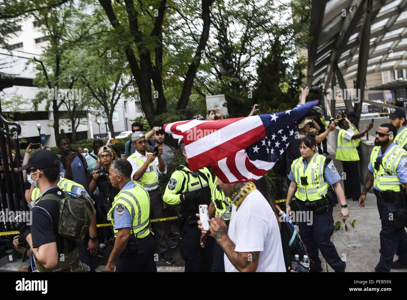 Washington D.C, USA. 12th Aug, 2018. Members of the Alt-Right arrive at the Foggy Bottom Metro Station to begin the Unite the Right 2 rally in Washington, DC.Despite predictions of a huge rally by the Alt-Right celebrating the first anniversary of the Unite The Right rally in Charlottesville, Virginia, only 15 showed up to march in Washington, DC on Saturday August 12. The small group was met by over a thousand anti-fascist protesters who marched from the city's Freedom Plaza to meet the handful of white supremacists who gathered under police guard under at a park behind the Wh Stock Photo