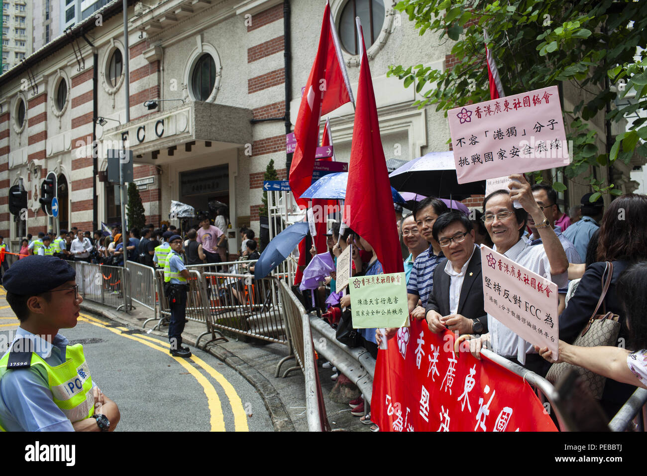 August 13, 2018 - Hong Kong, China - Pro-China demonstrators holding signs that read, â€œHong Kong Guangdong Association will not allow Hong Kong Independence elements to challenge national securityâ€. ..Two opposing groups gather outside the Foreign Correspondents Club in Hong Kong, one in support of its hosting a talk with Independent Party leader Andy Chan, and the other - in opposition. Hong Kong is taking measures to legally eliminate the party. (Credit Image: © Viola Gaskell/SOPA Images via ZUMA Wire) Stock Photo