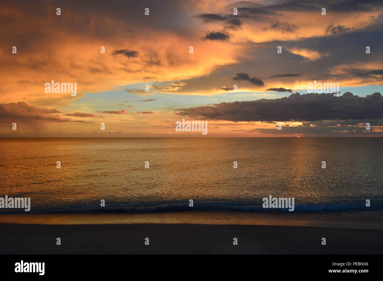 Nautical Coastal Summer Beachscape Seascape Scenic Tropical Island Evening Sunset Calming Relaxing Serene Vacation Beach Shore Water Sky Clouds Scene Stock Photo