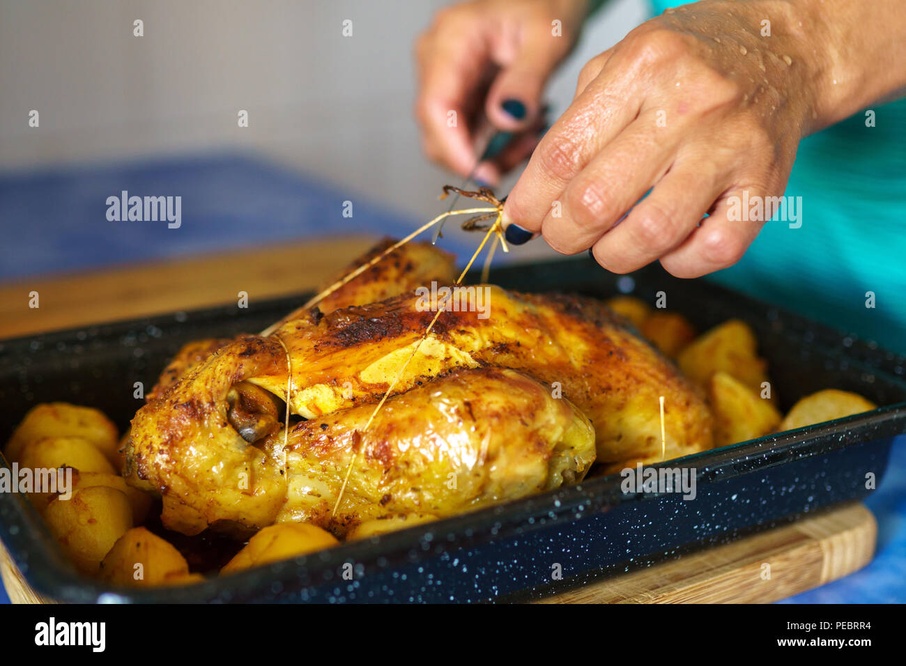 Whole chicken slow cooked in the oven with potatoes in the tray Stock