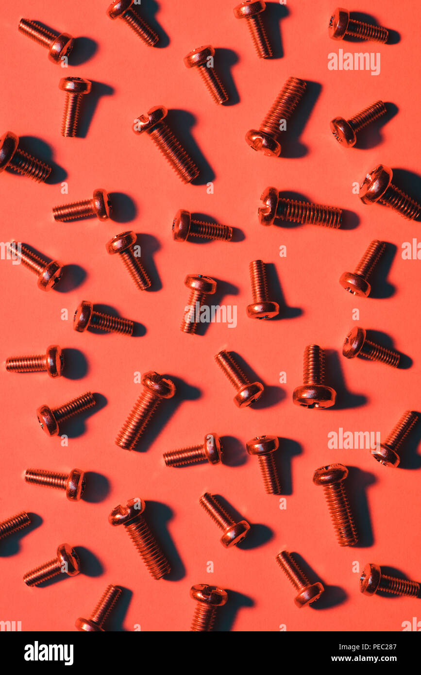 set of small metal screws on red Stock Photo - Alamy