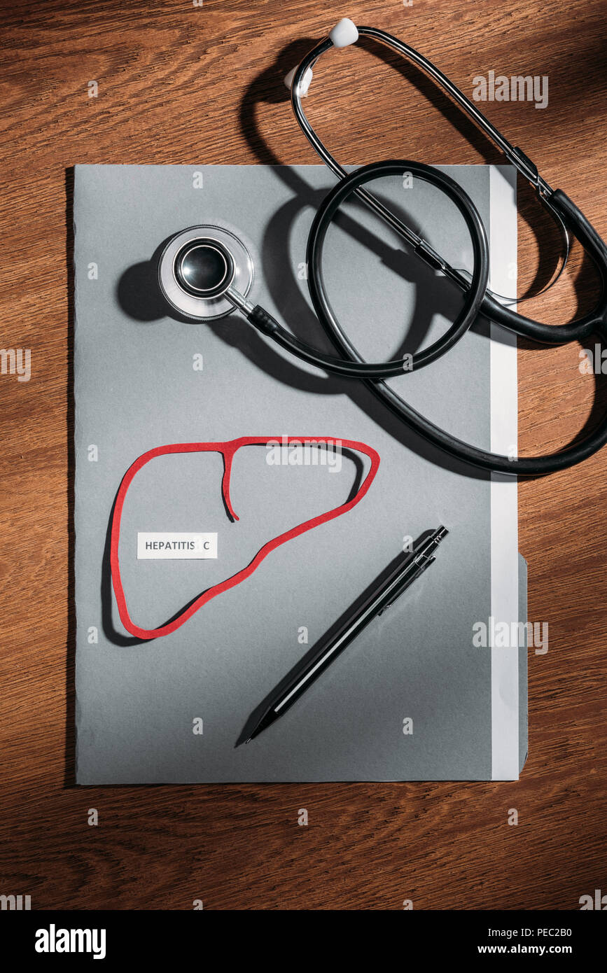 top view of folder, stethoscope, and liver with lettering hepatitis c on table, world hepatitis day concept Stock Photo