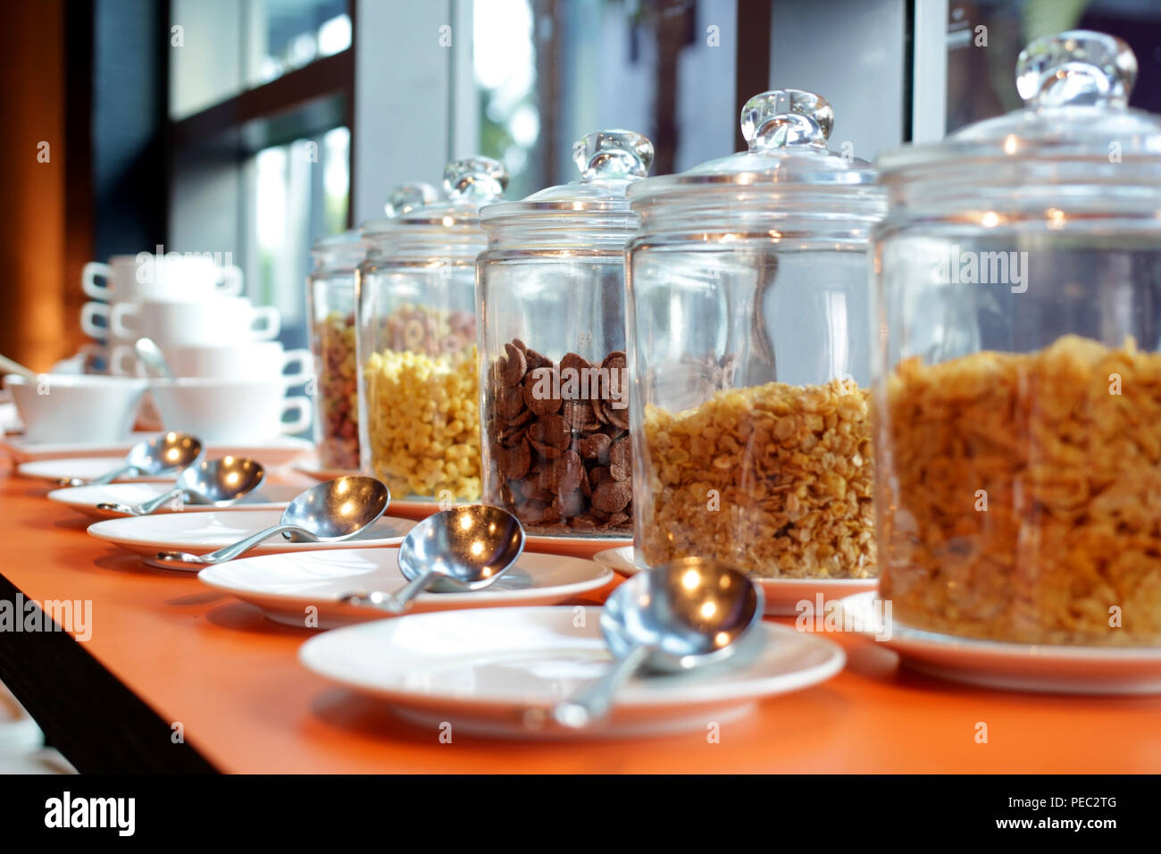 different kind of cereal cornflakes in a glass jar on buffet table Stock Photo