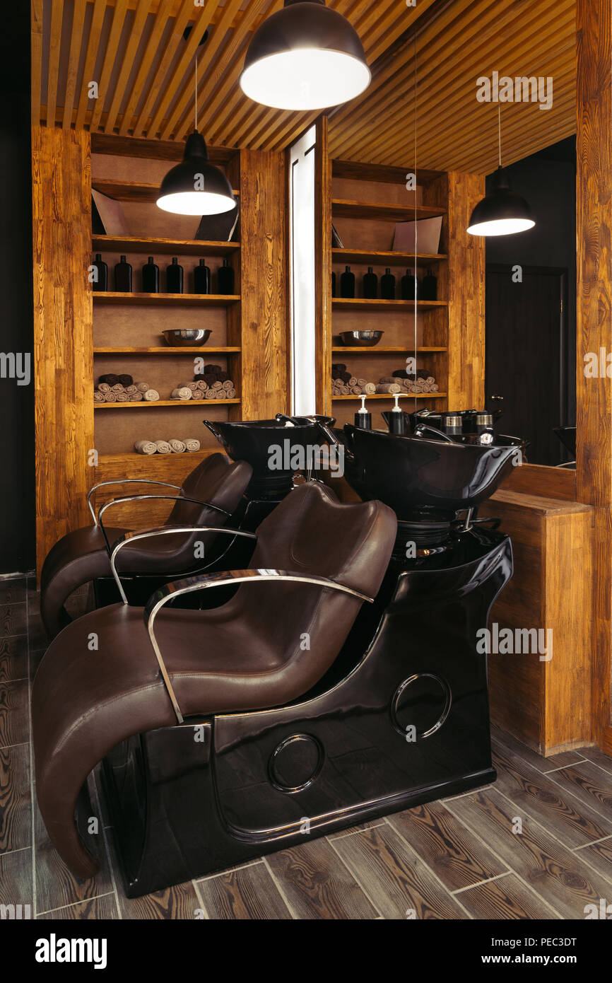 empty leather chairs and sinks in modern hair salon Stock Photo Alamy