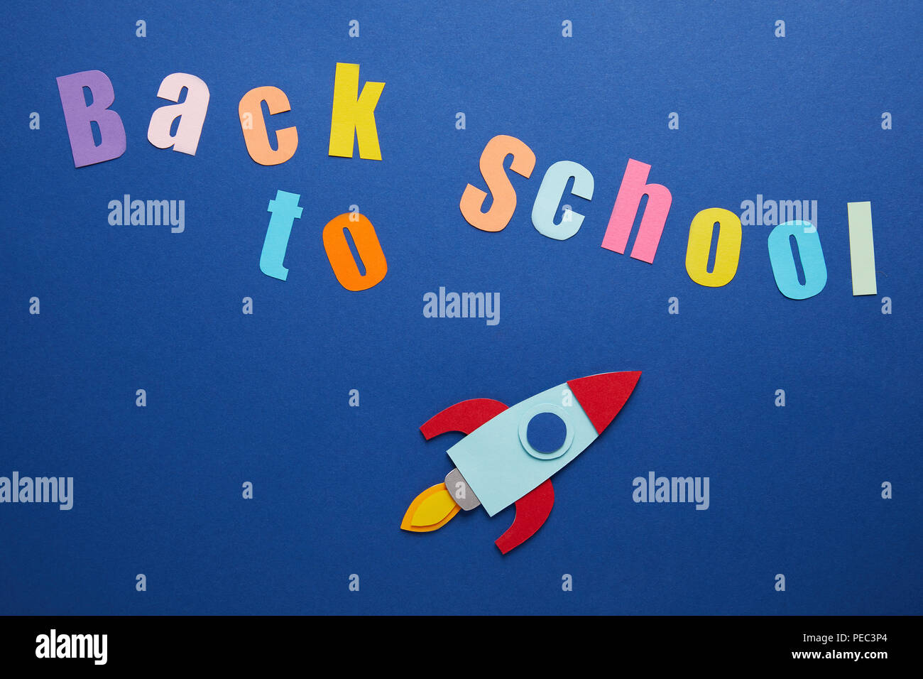top view of back to school lettering with rocket on blue background ...