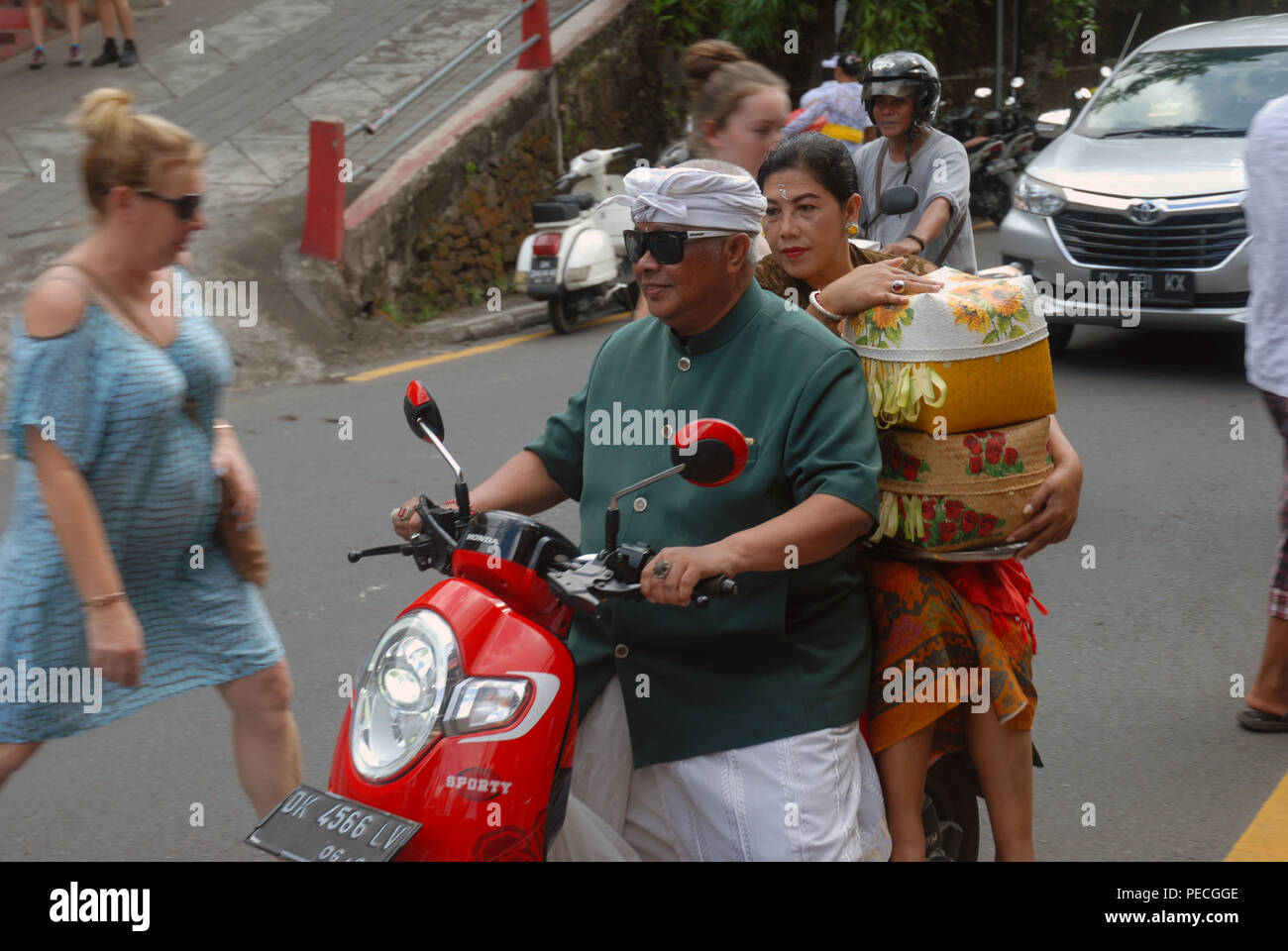 Man giving his wife a ride on back of scooter, Ubud, Bali. Indonesia