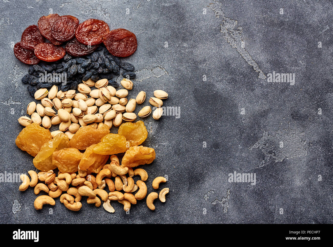 Mix dried fruits and nuts on gray background. Top view of superfoods