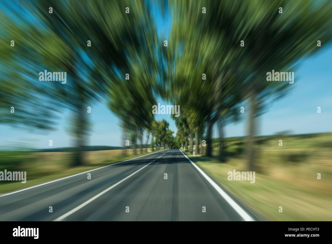 driving fast on road in rural landscape - motion blur Stock Photo