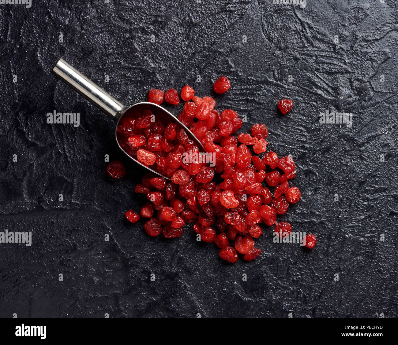 Dried red cherry on black background with scoop Stock Photo