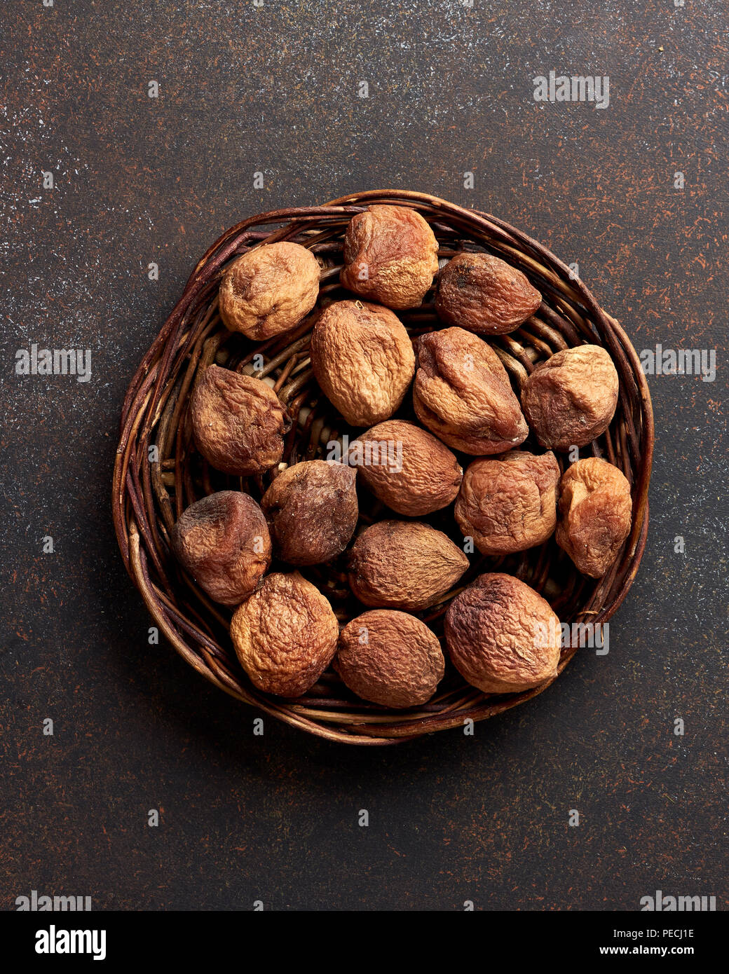Sun dried apricots on brown background. Top view. Stock Photo