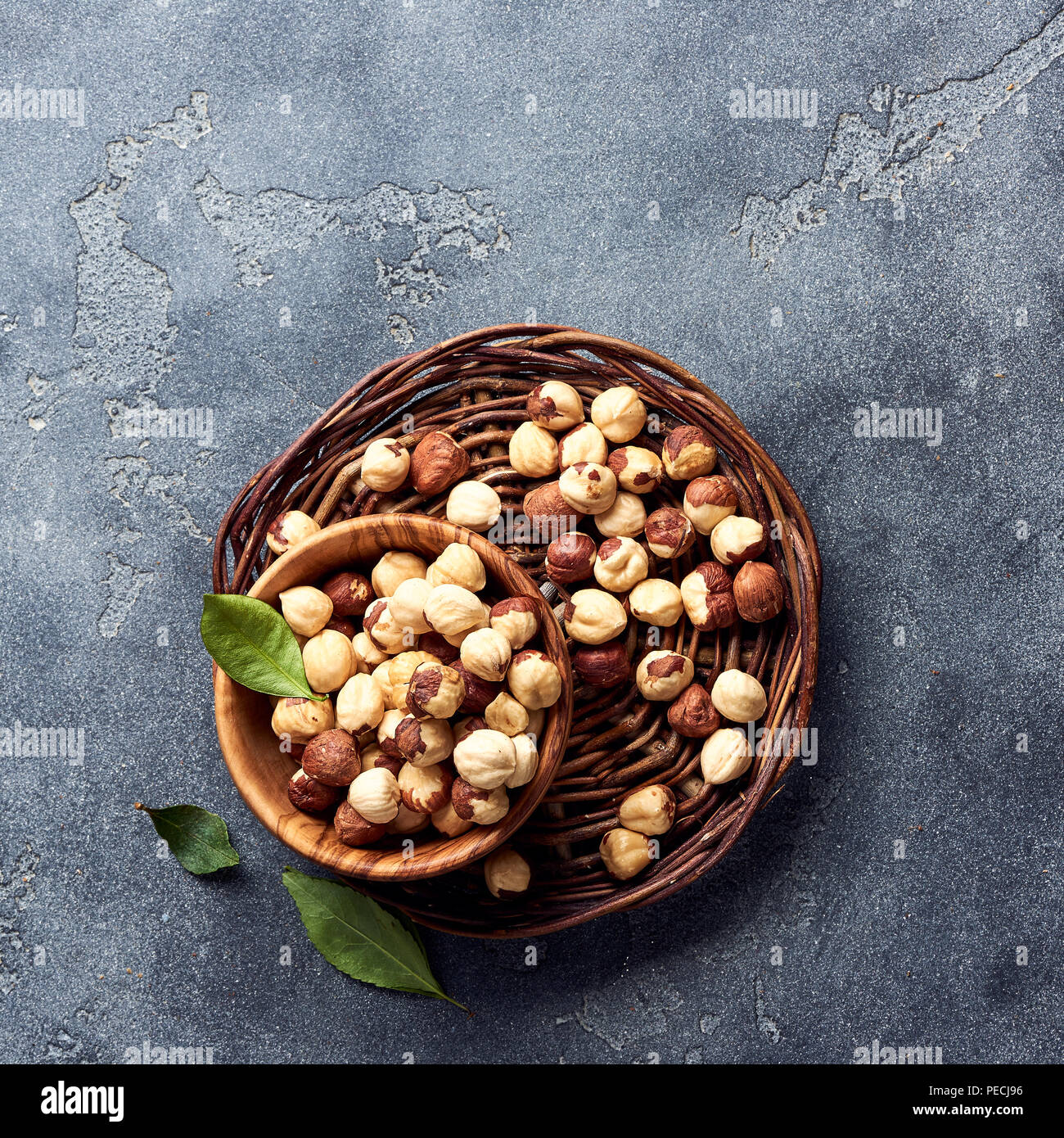 Hazelnuts and green leaves on gray background Stock Photo
