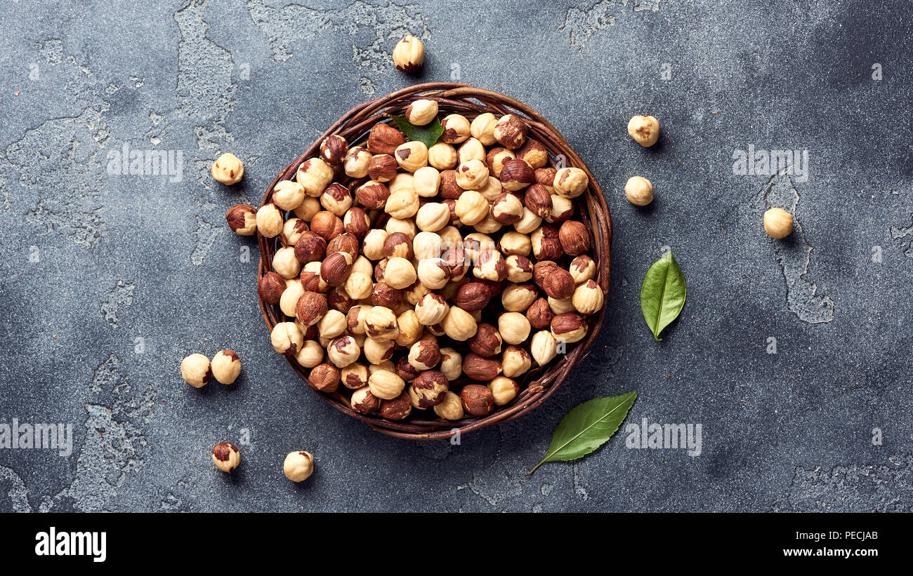 Hazelnuts and green leaves on gray background Stock Photo