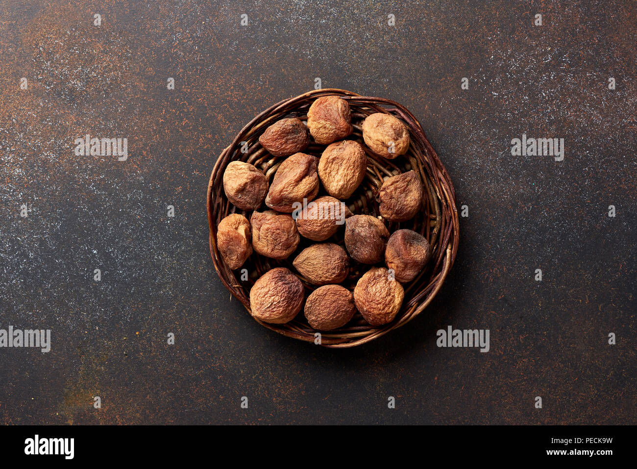 Sun dried apricots on brown background. Top view. Stock Photo