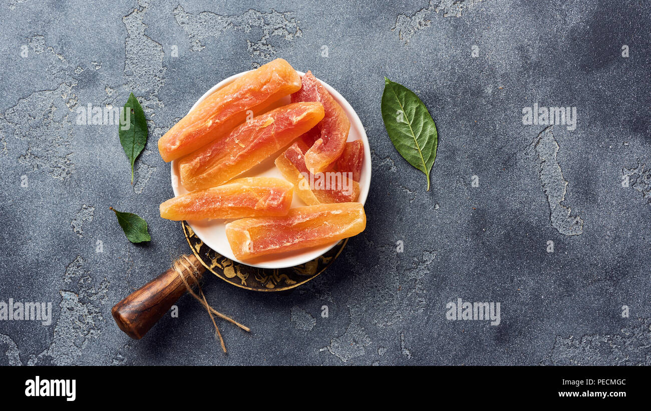 Dried sweet papaya sticks. Candied fruits on gray background. Top view
