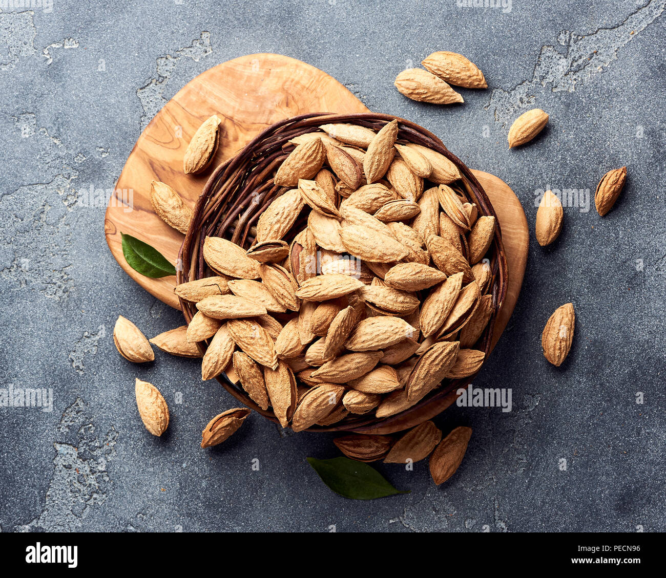 Unshelled almonds on gray concrete background. Top view. Stock Photo