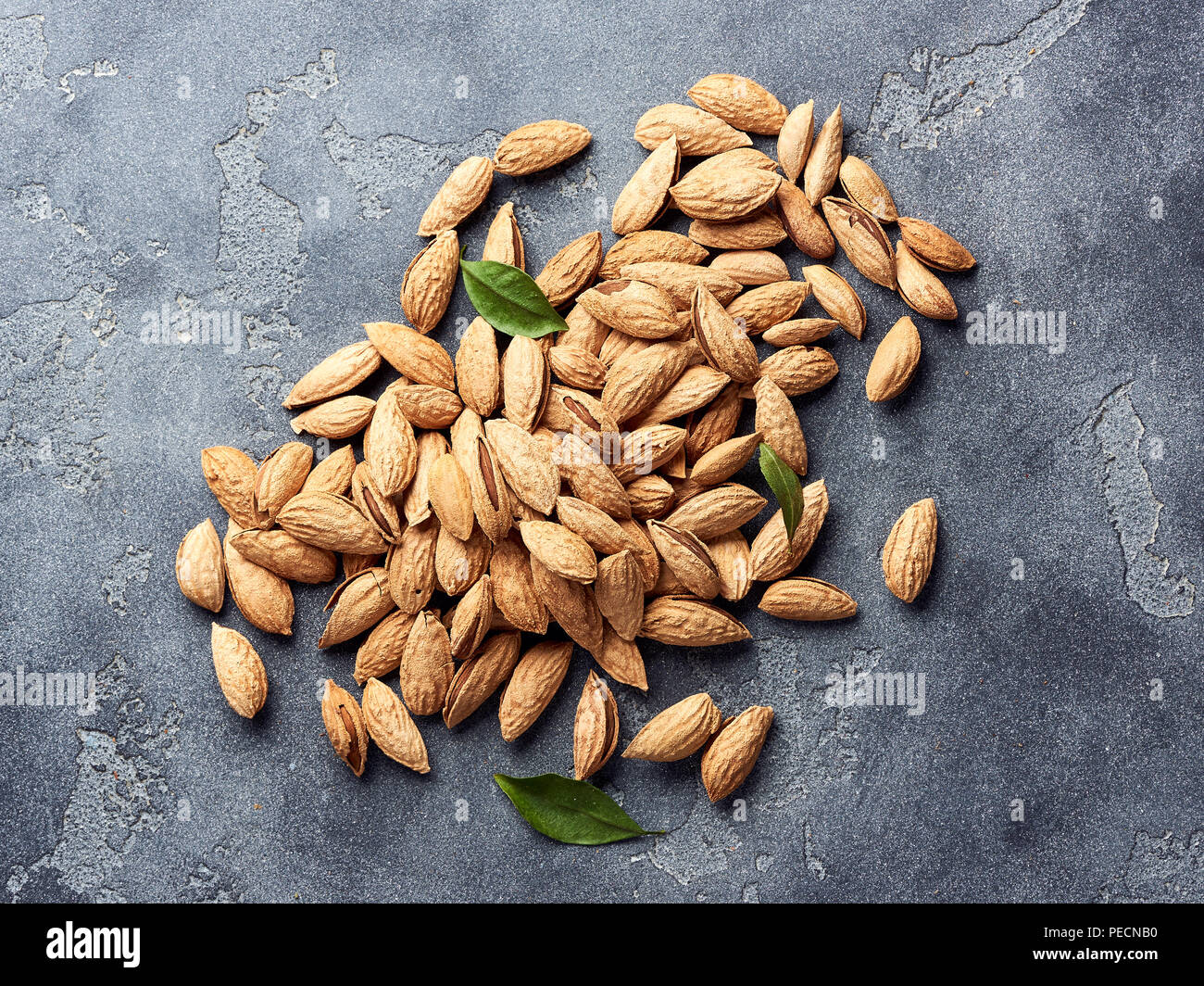 Unshelled almonds on gray concrete background with copy space. Top view. Stock Photo