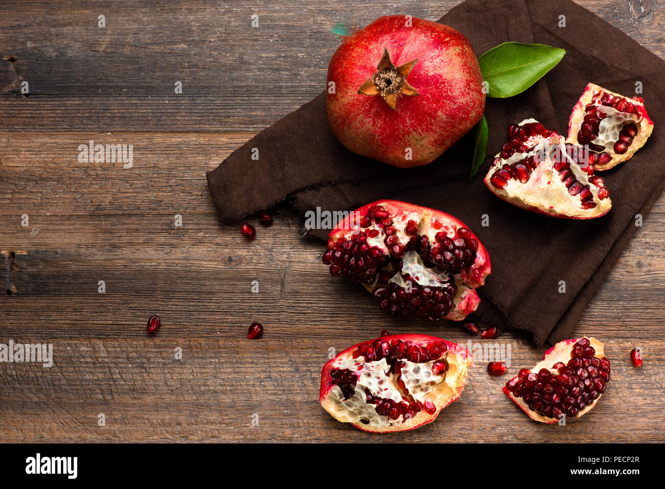 Pomegranate fruits with grains on wooden table. Top view. Stock Photo