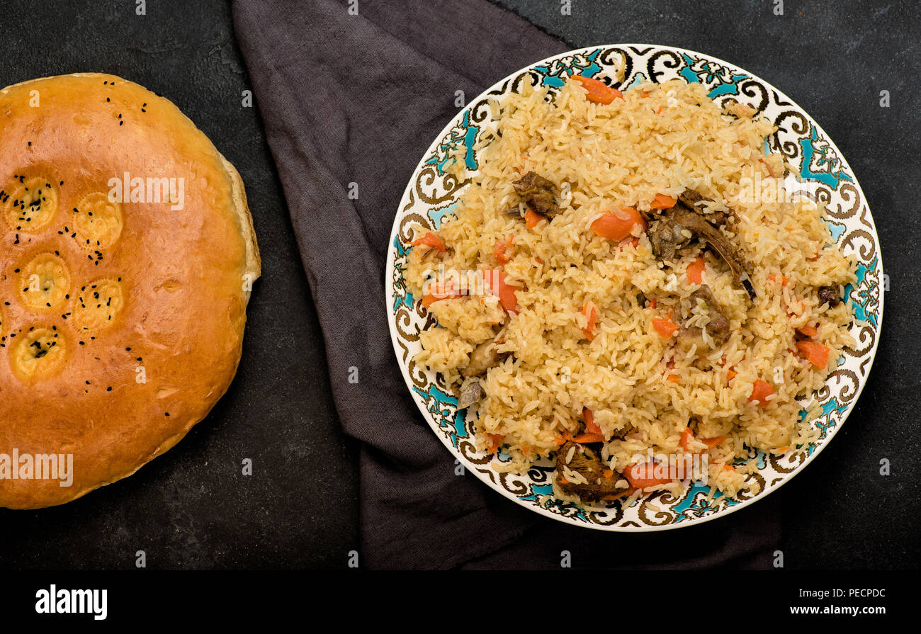 Pilaf on plate with oriental ornament and Traditional Asian breads - churek. Plov. Top view. Stock Photo