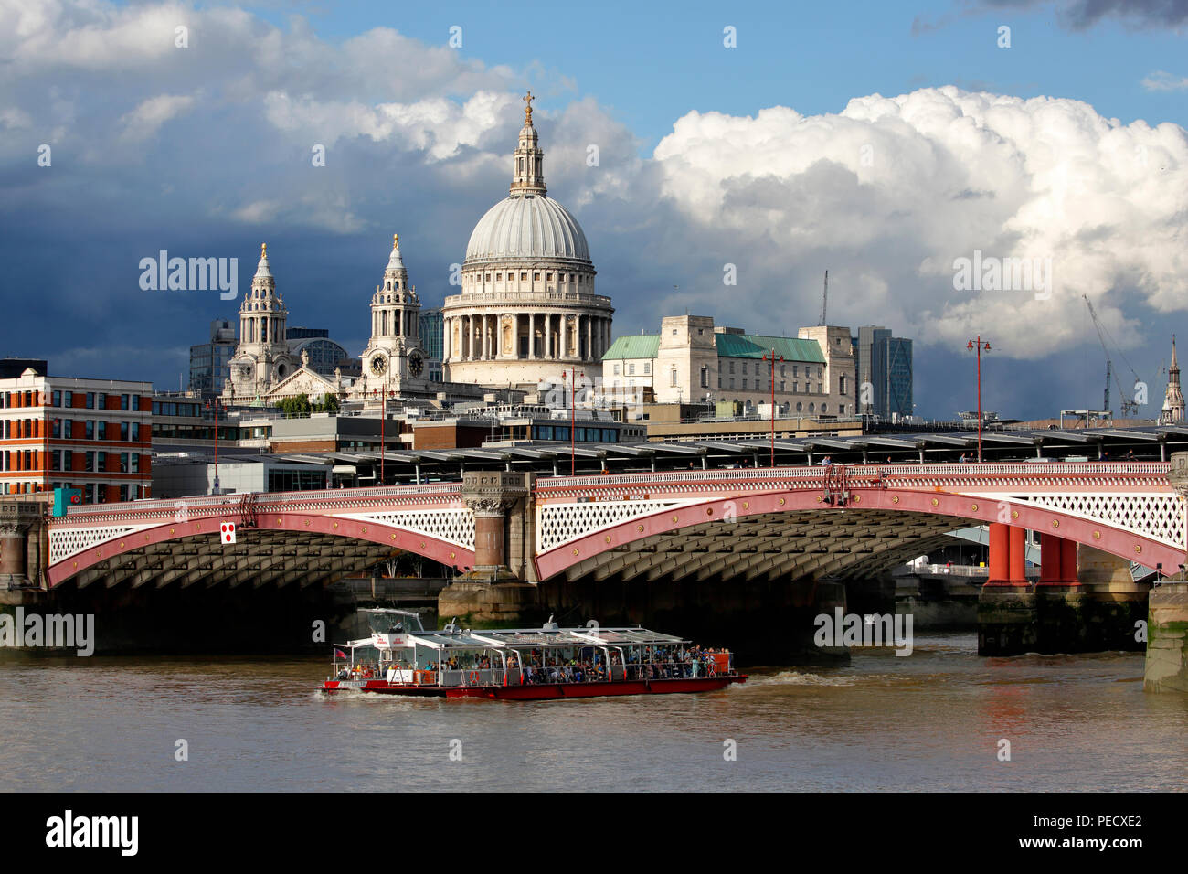 St Paul's Cathedral London with Blackfriars bridge and a Thames tourist tours boat in the foreground Stock Photo