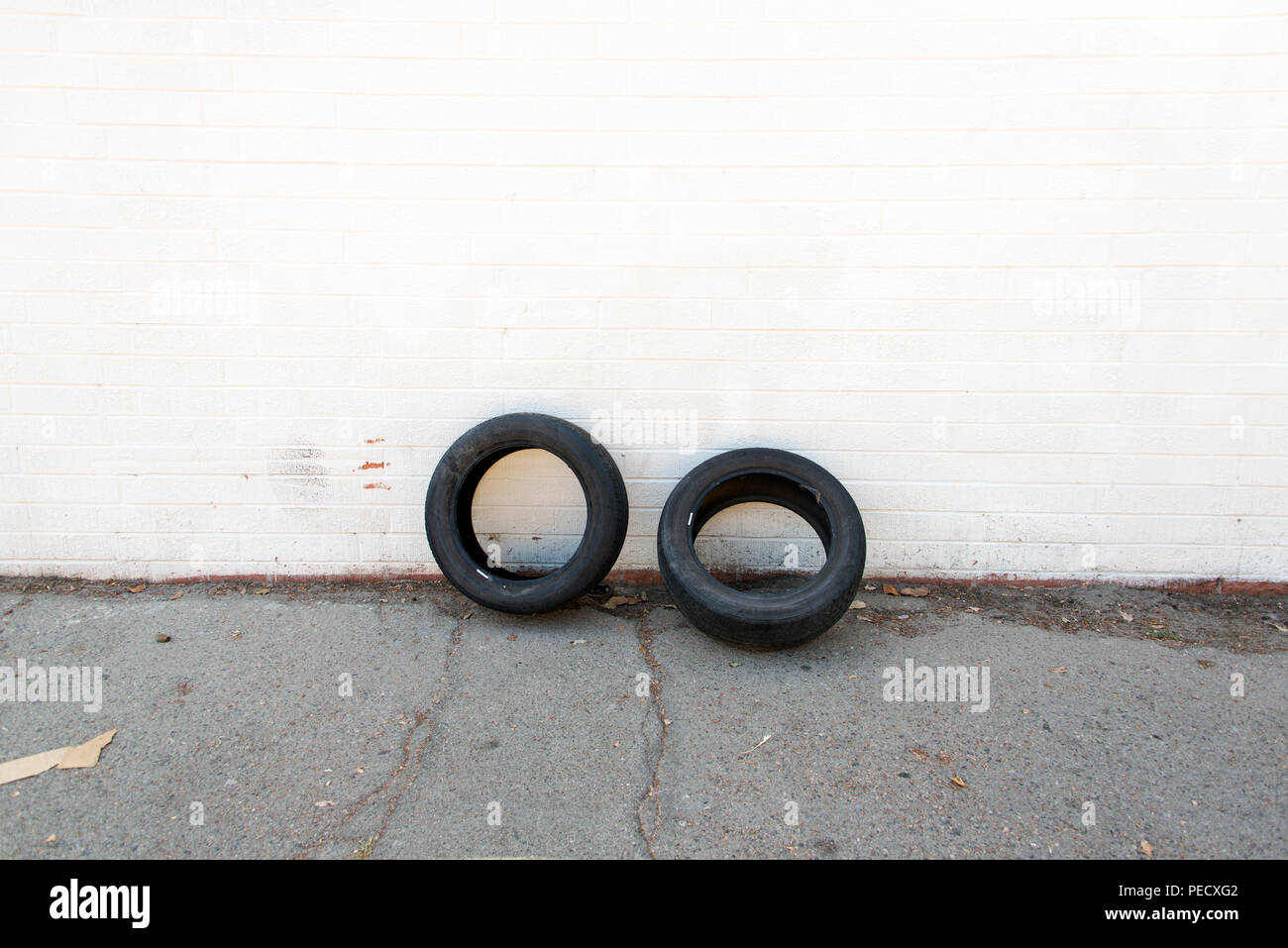 Two car tires leaning on a white wall Stock Photo Alamy