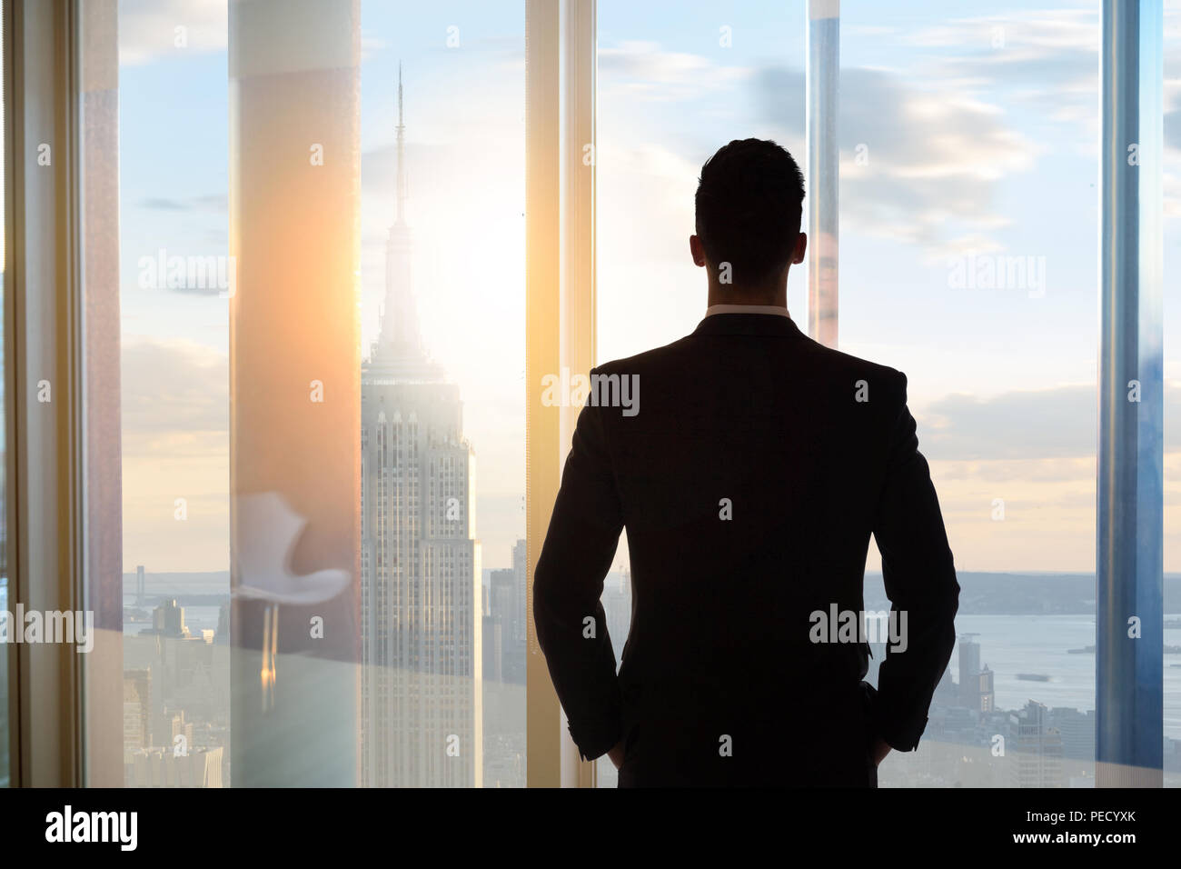 businessman looking out window down on city Stock Photo