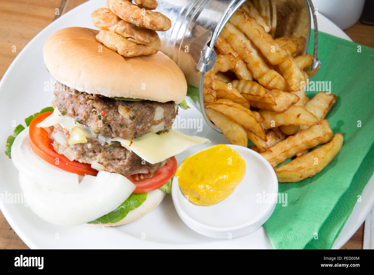 Homemade double hamburger and cheese with a bucket/pail of potato chips/fries and English