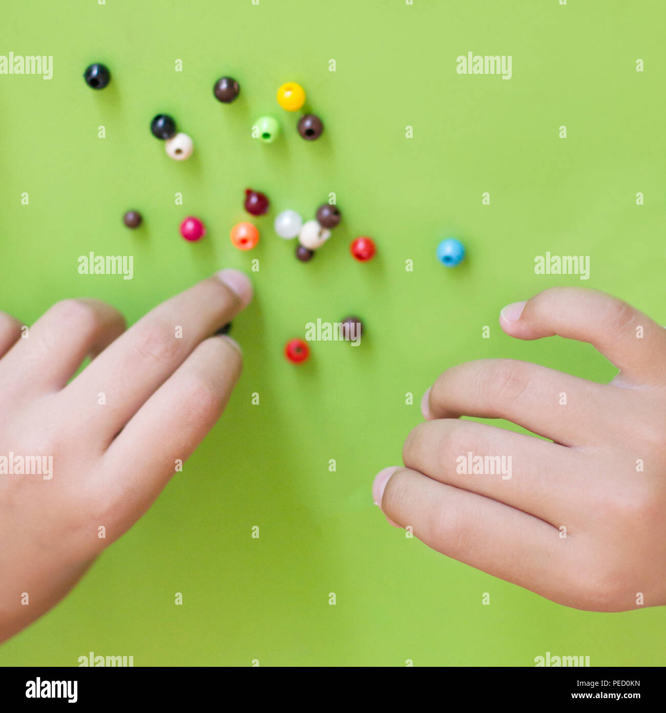 Girl's hand stringing beads on a string Stock Photo Alamy